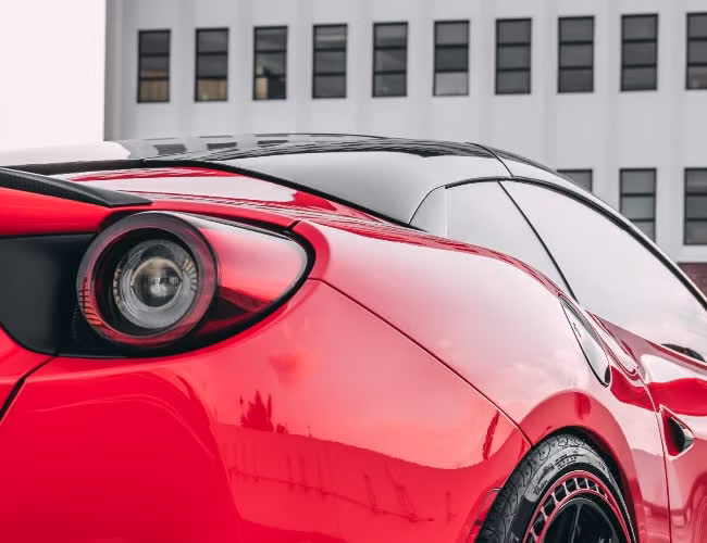 Close-up of the rear haunch and taillight of a red Ferrari protected with clear XPEL film by Monarch