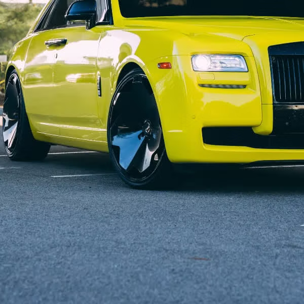 Close-up of the wrapped front fender and wheel on a yellow Rolls-Royce Ghost by Monarch Wrap & Tint