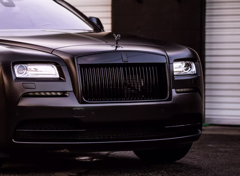Close-up of the satin black finish, blacked-out grille and Spirit of Ecstasy on a Rolls-Royce Wraith wrapped by Monarch
