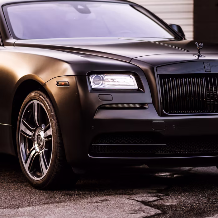 Close-up of the wrapped door and wheel on a satin black Rolls-Royce Wraith by Monarch Wrap & Tint