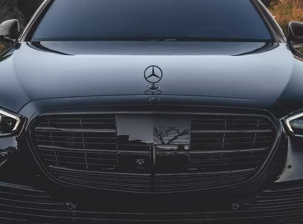 Close-up of the blacked-out grille and darkened star badge on a black Mercedes-AMG S63 by Monarch